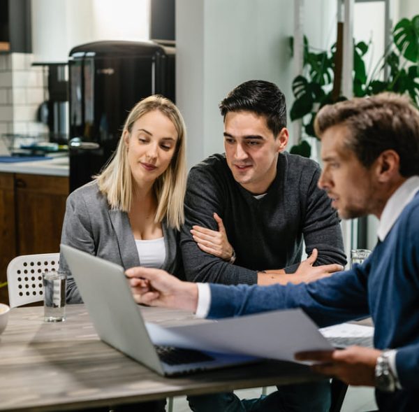 young-couple-real-estate-agent-using-laptop-while-going-through-housing-plan-meeting (2) (2)